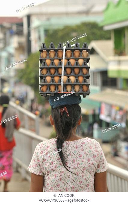 woman carrying eggs on her head across Friendship Bridge from Mae Sot, Thailand to Myawaddy, Myanmar Burma