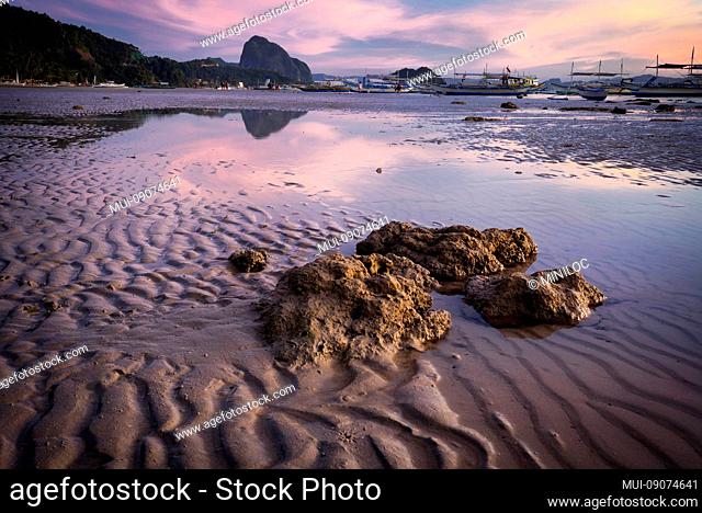 Blue hour at tropical harbor bay in evening. Tranquil sunset in lagoon shallow water and sandy beach in Philippines, Palawan, El Nido