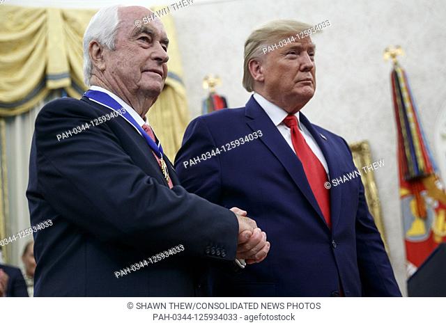 US President Donald J. Trump (R) awards the Presidential Medal of Freedom to American racing magnate Roger Penske (L) during a ceremony in the Oval Office of...