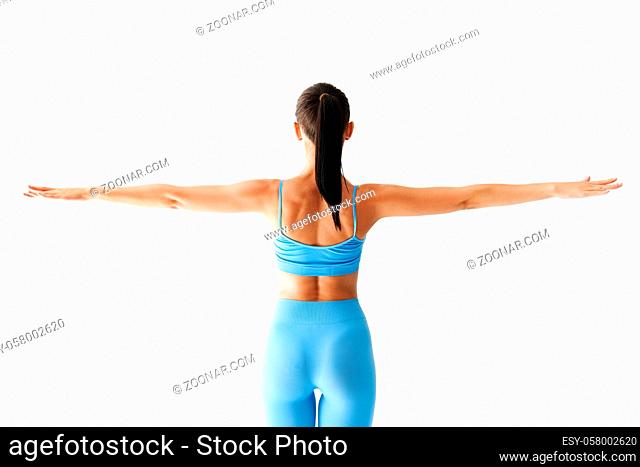 Back view of sporty woman with arms outstretched on white background