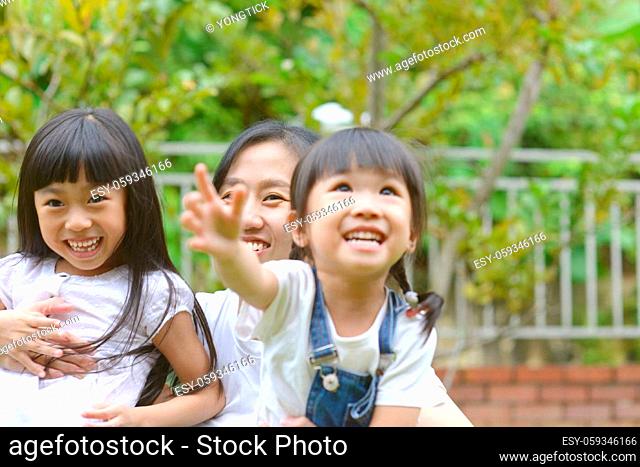 Enjoying time together.Lifestyle portrait asian mother and daughters in happines at the outside of garden park