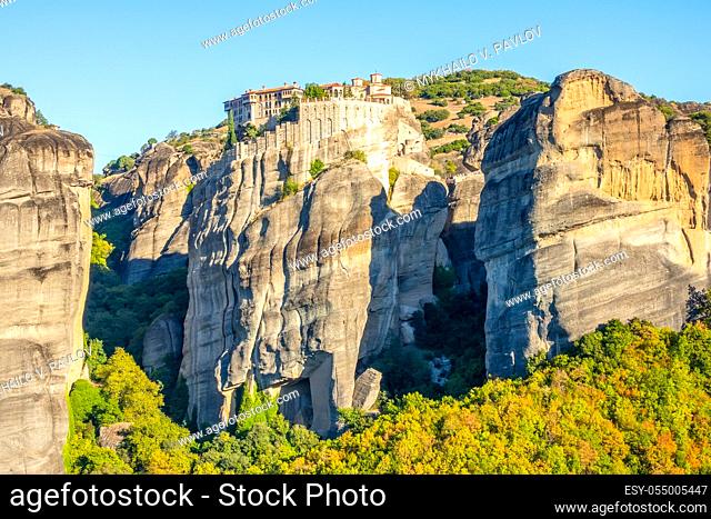Greece. Clear summer day in Meteora. Several buildings of a rock monastery with red roofs against a cloudless blue sky
