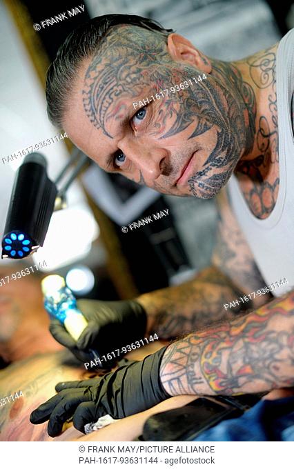 A tattoo artist doing his work, Germany, city of Michelstadt, 13. August 2017. Photo: Frank May (model released) | usage worldwide