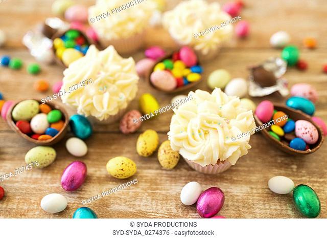cupcakes with chocolate eggs and candies on table