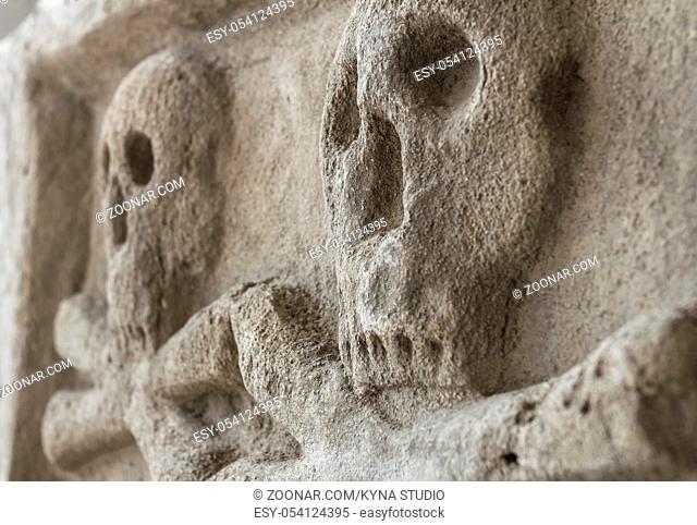 Ancient stone skull with crossbones. Old sculpture. Ideal for concepts and backgrounds