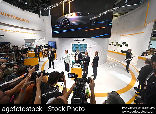 05 September 2023, Bavaria, Munich: Photographers take pictures of the stand of Continental German Chancellor Olaf Scholz (M) at the opening of the IAA The...