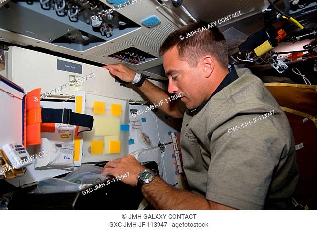 Astronaut Christopher Cassidy, STS-127 mission specialist, works on the middeck of Space Shuttle Endeavour during flight day two activities