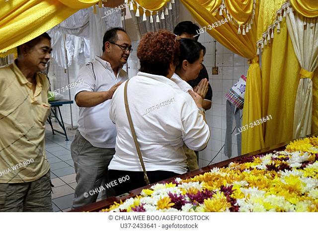 Widow grieving the death of her husband. Sarawakian chinese funeral ceremony. Malaysia