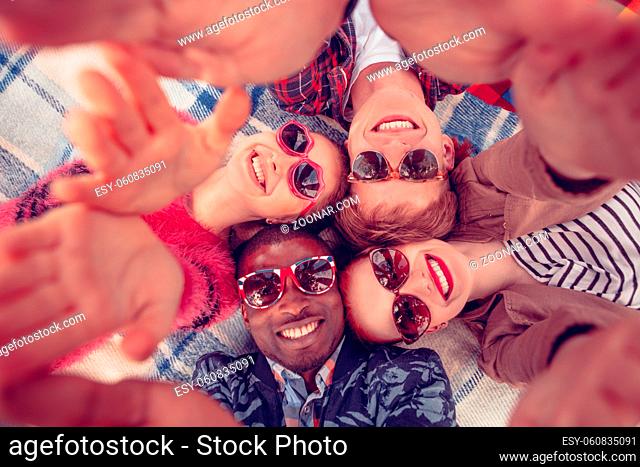 Image of best friends making selfies on picnic. Happy people looking at camera and smiling while lying on picnic rug in parklane