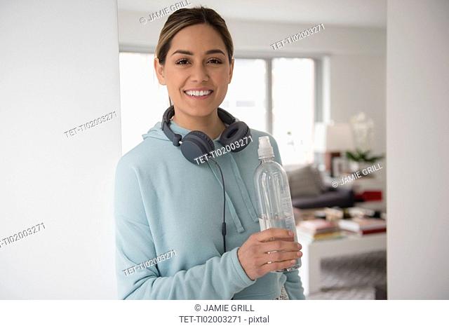 Portrait of young woman holding water bottle