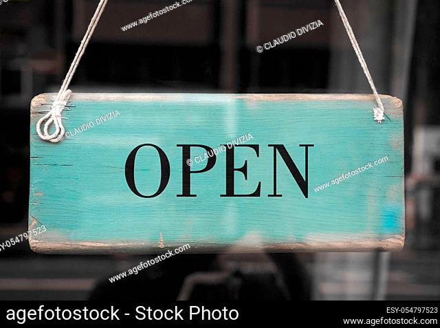 Open sign in a shop window with reflections