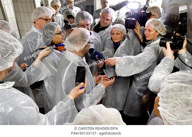 Martin Schulz (c), leading candidate of the SPD party for the general elections, talks to journalists during a visit to a fish smokehouse together during an...