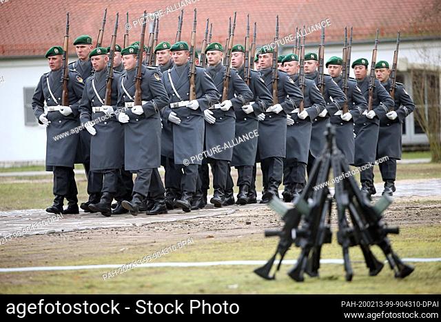 13 February 2020, Brandenburg, Strausberg: Soldiers of the Guard Battalion of the German Army march in the von Hardenberg Barracks past mounted Heckler & Koch...