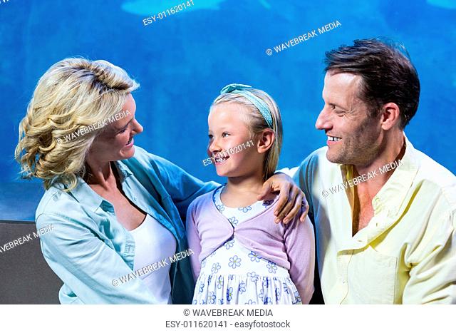 Happy family standing beside the fish tank
