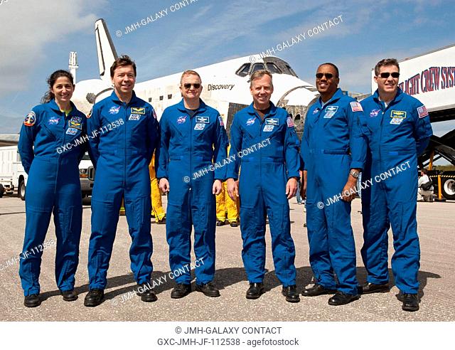 The STS-133 crew poses for a photo in front of space shuttle Discovery on the Shuttle Landing Facility's Runway 15 at NASA's Kennedy Space Center in Florida