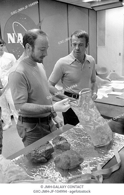 The two moon-exploring crewmen of the Apollo 14 lunar landing mission show off some of the largest of the lunar rocks they collected on their mission