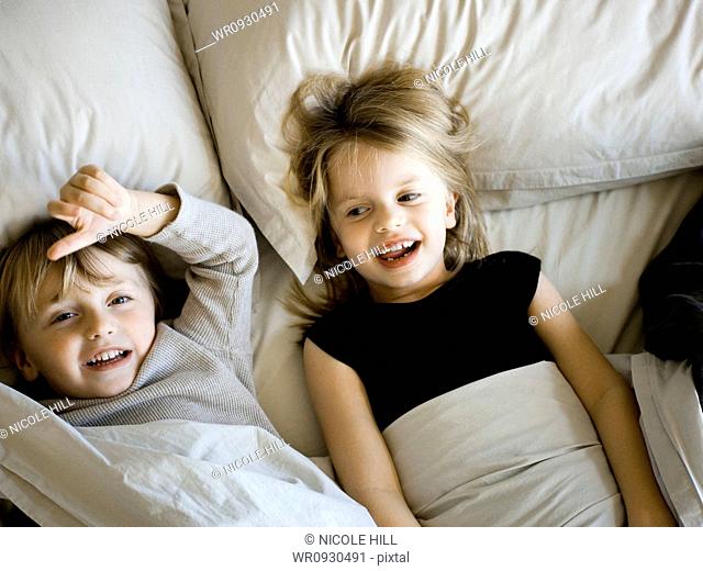 USA, Utah, Provo, Portrait of brother and sister 2-5 lying in bed