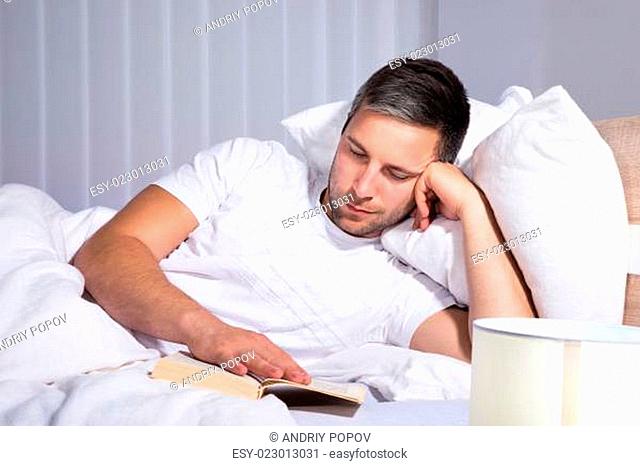Man Reading Book While Relaxing