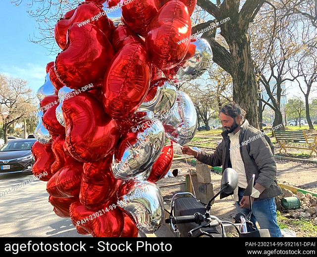 14 February 2023, Pakistan, Islamabad: Mohamed Farman, a street vendor in Islamabad, sells heart balloons for Valentine's Day.