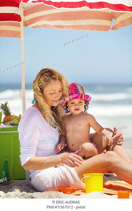 Woman with her daughter sitting on the beach