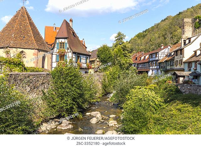 scenic corner in the center of Kaysersberg, Alsace, France, old half-timbered houses and Chapelle de l'Oberhof at the river