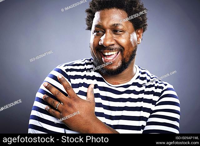 Studio portrait of mid adult man laughing