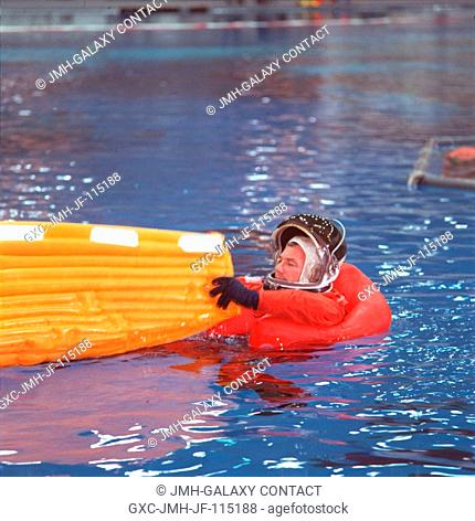 Astronaut Terrence W. (Terry) Wilcutt, STS-106 mission commander, empties water from his newly-deployed life raft during a simulation of an emergency bailout...