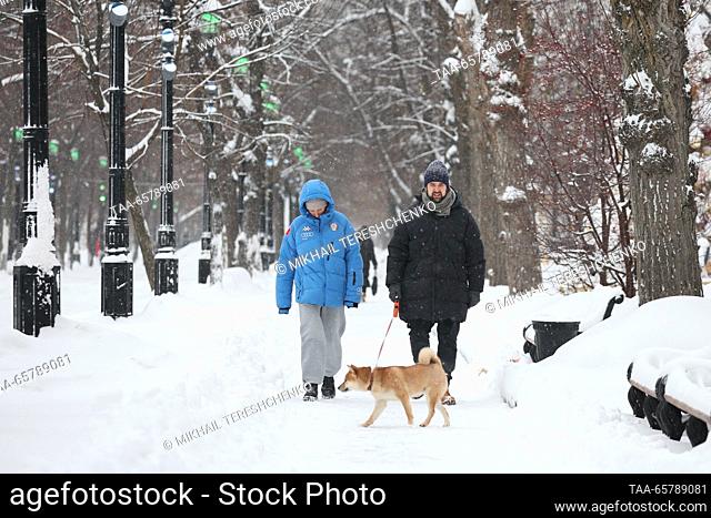 RUSSIA, MOSCOW - DECEMBER 15, 2023: People walk their dog in central Moscow after a snowfall. Mikhail Tereshchenko/TASS