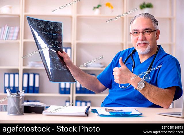 White bearded old doctor radiologist working in clinic