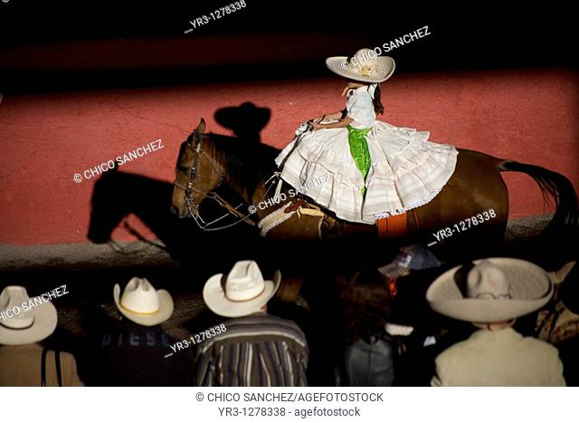 Spectators watch a Mexican amazona ride her horse at the National Charro Championship in Pachuca, Hidalgo State, Mexico. Escaramuzas are similar to US rodeos