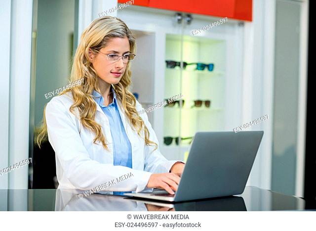 Optometrist using laptop in ophthalmology clinic