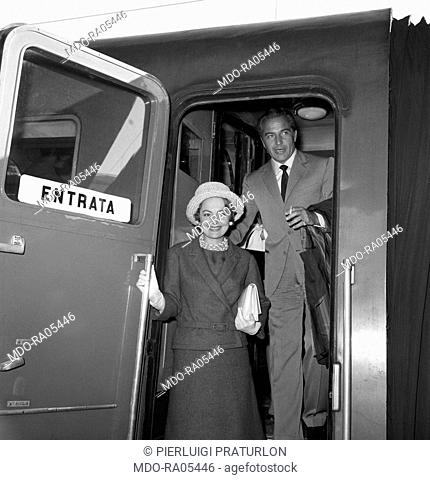 British actress Olivia de Havilland and Italian actor Rossano Brazzi getting out of a train. Italy, 28th May 1961