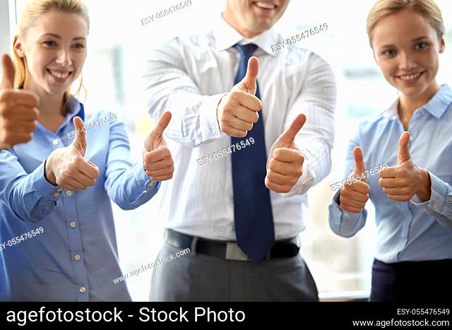 happy business team showing thumbs up at office
