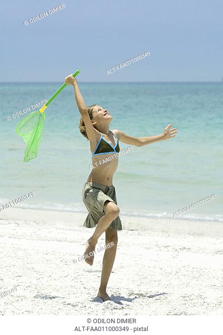 Girl standing with fishing net on beach