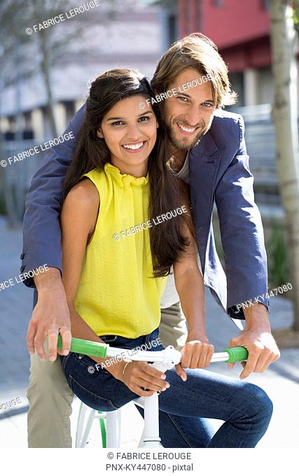 Portrait of a smiling couple riding a bicycle