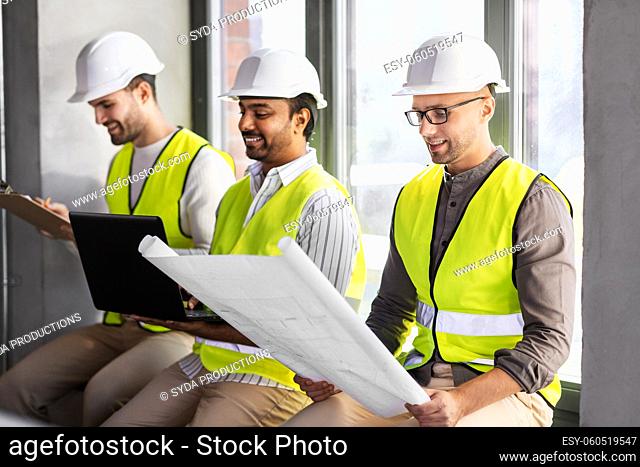 male architects in helmets working at office