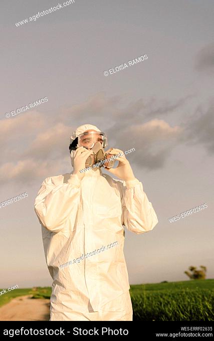 Man wearing protective suit and mask in the countryside