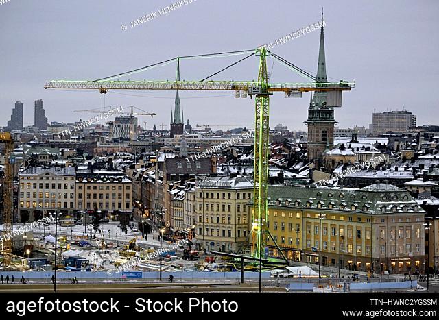 Apicture taken on Dec. 14, 2023, shows a construction crane illuminated in green with the Stockholm skyline in the background