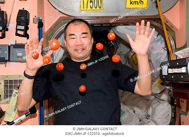 Japan Aerospace Exploration Agency (JAXA) astronaut Soichi Noguchi, Expedition 23 flight engineer, is pictured near fresh tomatoes floating freely in the Unity...