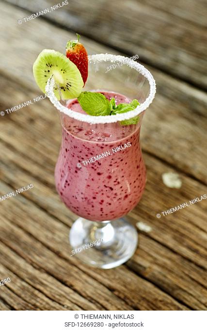 A strawberry smoothie in a glass with a sugared rim
