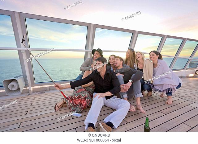 Group of friends taking selfies on a cruise