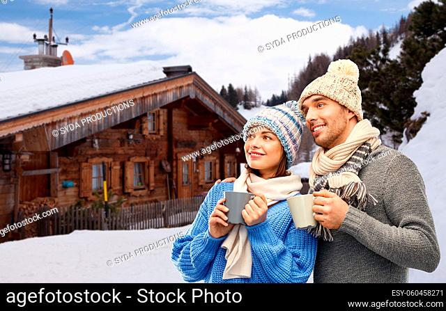 happy couple with mugs drinking coffee in winter