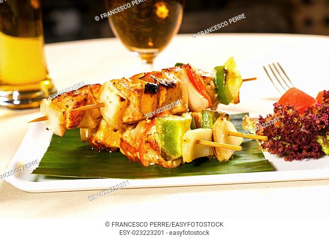 fresh chicken and vegetables skewers on a palm leaf thai style