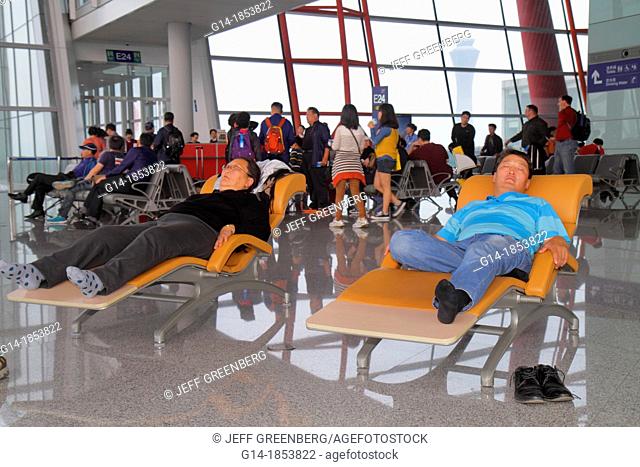 China, Beijing, Beijing Capital International Airport, PEK, terminal, concourse, gate area, pasengers, travelers, Asian, man, woman, lounge chair, sleeping