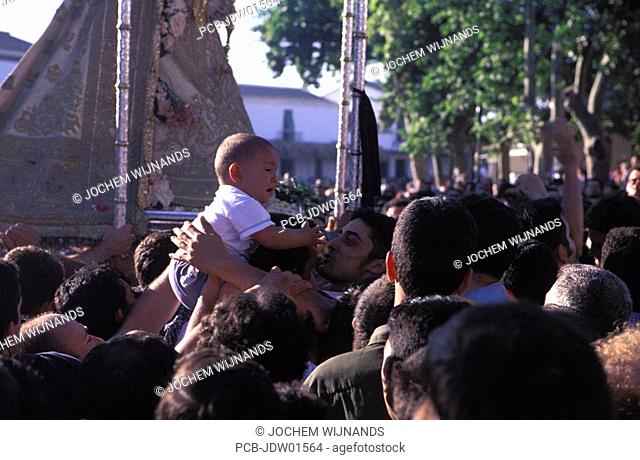 el rocio, a baby is carried over the crowd to touch la paloma blanca