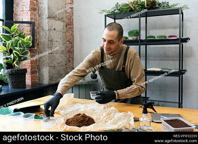 Man working on microgreens on table