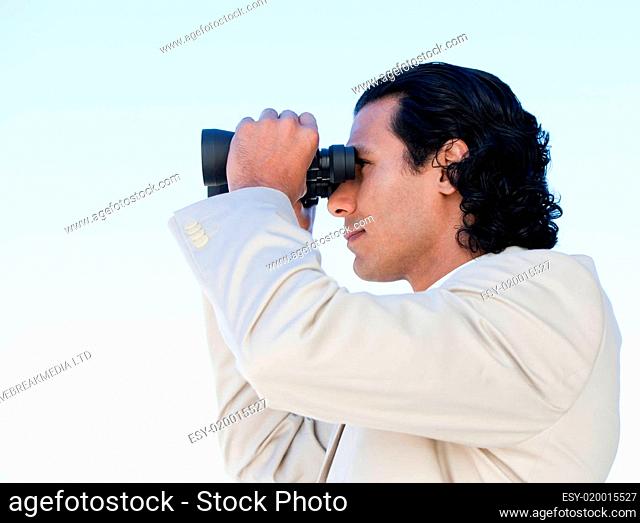Portrait of a latin business man looking through binoculars