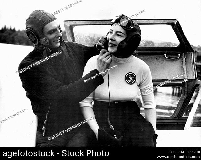 Cobb Disaster Does Not Deter Them - Mr. Hanning-Lee adjusts the sharp of his wife's helmet in the cockpit of their jet-propelled speedboat ""White Hawk"" on...