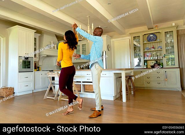 Happy couple dancing in their kitchen