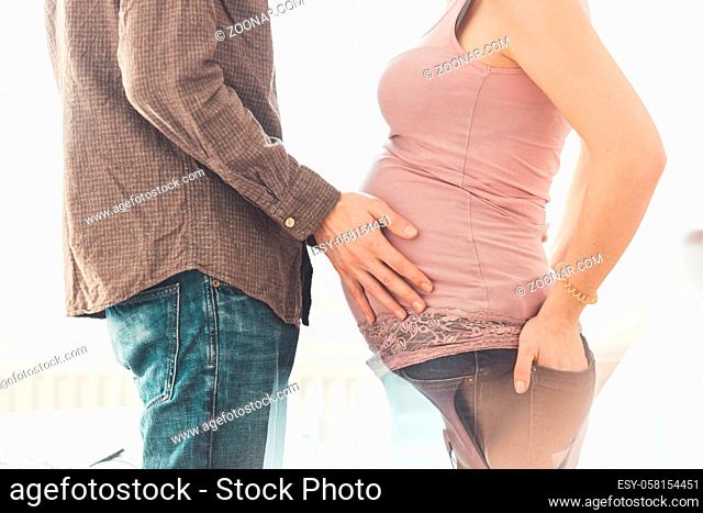 Close up of pregnant mother and father, hugging the tummy, Caucasian